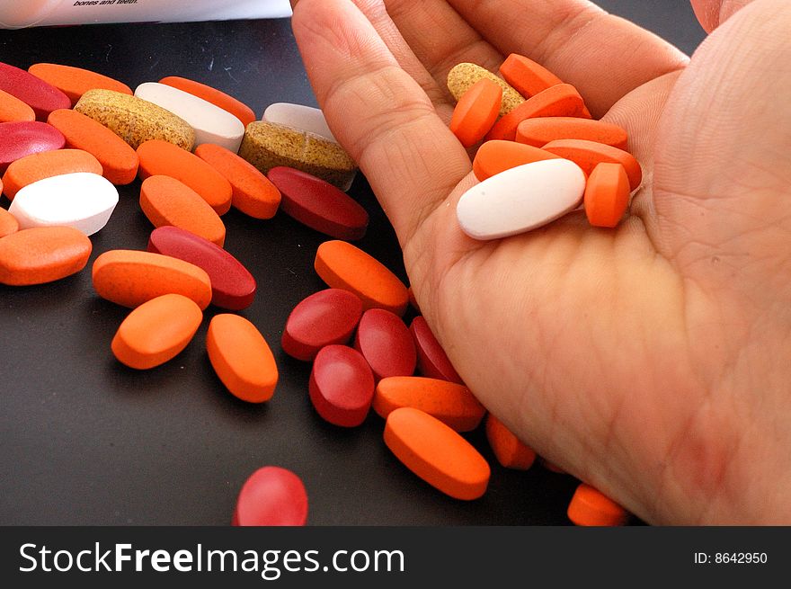 An image of an open palm holding a handful of pills. An image of an open palm holding a handful of pills.