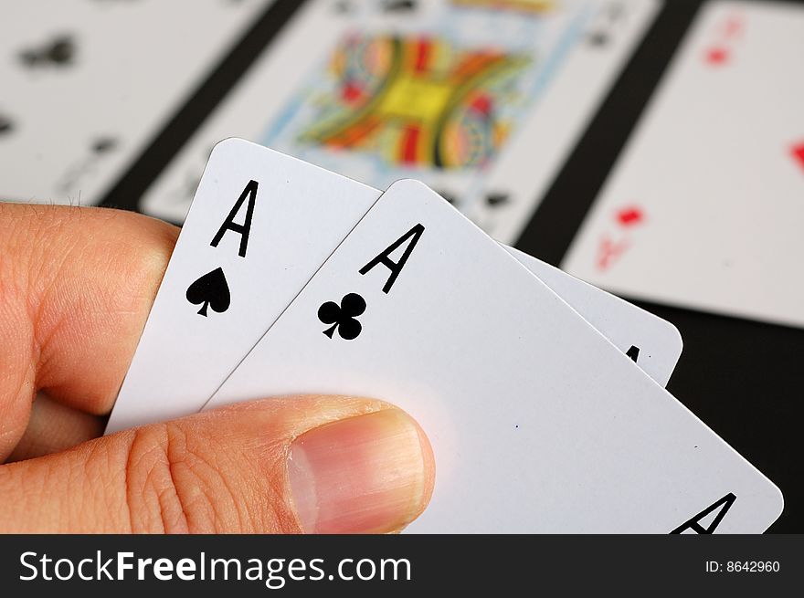 An image of someone holding two aces while playing poker. An image of someone holding two aces while playing poker.