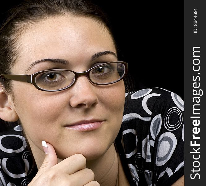 Portrait of a studious looking brunette on a black background. Portrait of a studious looking brunette on a black background.