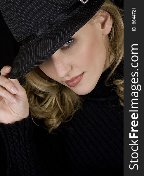 Beautiful image of a blonde woman looking up from under a hat. Beautiful image of a blonde woman looking up from under a hat.
