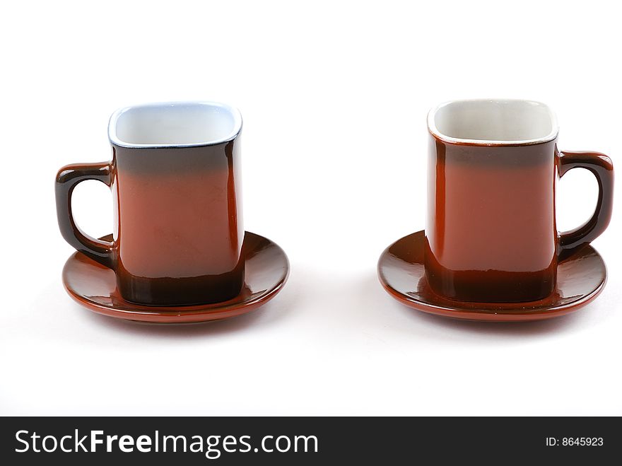 Brown cups for tea and coffee. A small white teapot.