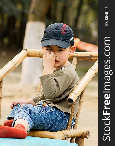 A picture of a little chinese boy picking nose