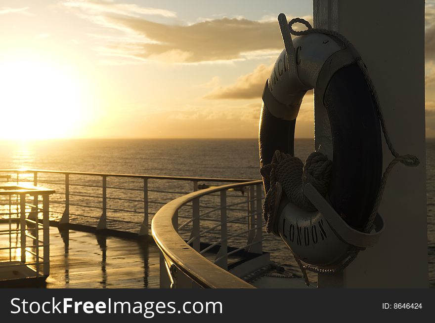 Looking across the deck of a ship at a sunrise and lifebouy. Looking across the deck of a ship at a sunrise and lifebouy