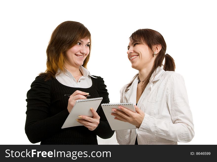 Two young businesswoman talk and smile. Two young businesswoman talk and smile