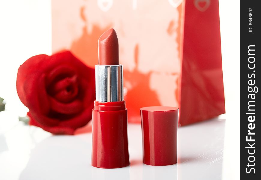 Package  lipstick and rose on background. Package  lipstick and rose on background