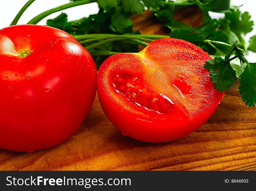 Tomato and coriander on a wooden plate