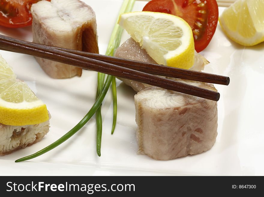 Pieces of smoked eel on a plate with garnish. Pieces of smoked eel on a plate with garnish