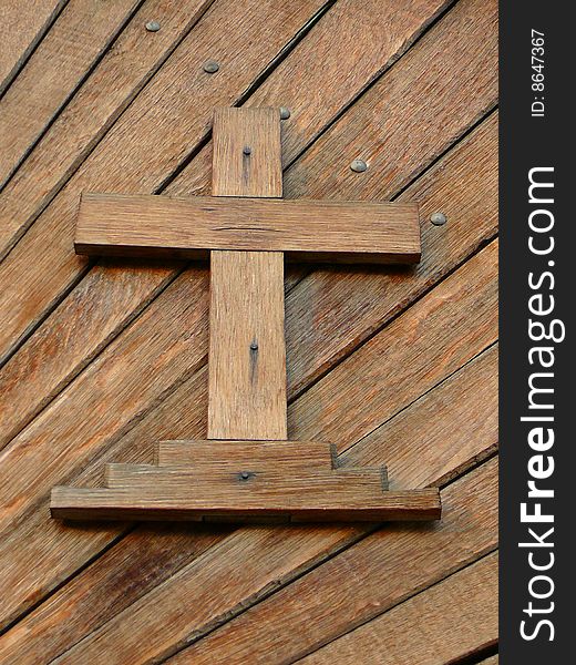 Detail cross inlayed in wooden door. Detail cross inlayed in wooden door.