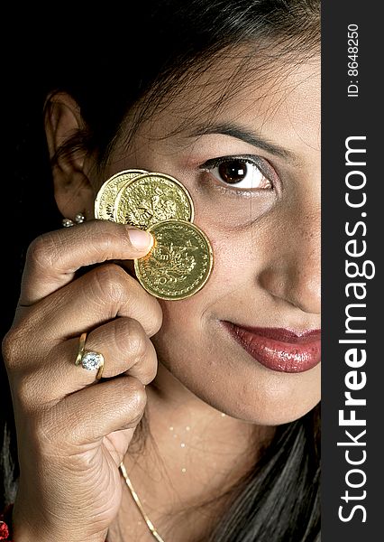 Girl holding gold coins in studio. Girl holding gold coins in studio.