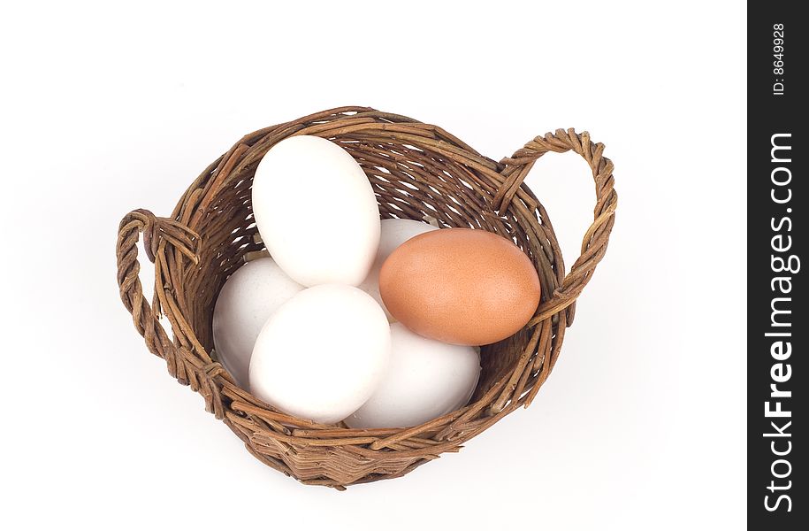 Chicken eggs in a basket on a white background