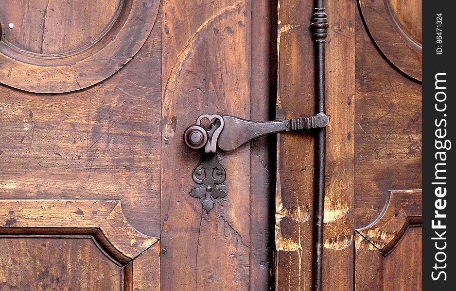 Close up of antique brass door knob and handle on rustic wooden door. Close up of antique brass door knob and handle on rustic wooden door.