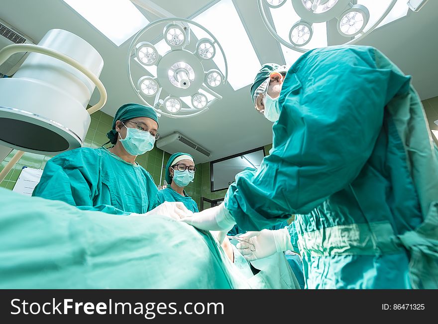 Surgeons working on table inside modern operating theater. Surgeons working on table inside modern operating theater.