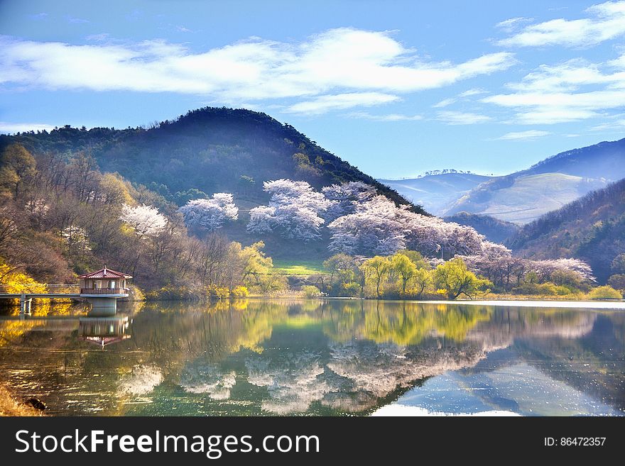 Hills and trees reflecting in calm lake in rural countryside on sunny day in Korea. Hills and trees reflecting in calm lake in rural countryside on sunny day in Korea