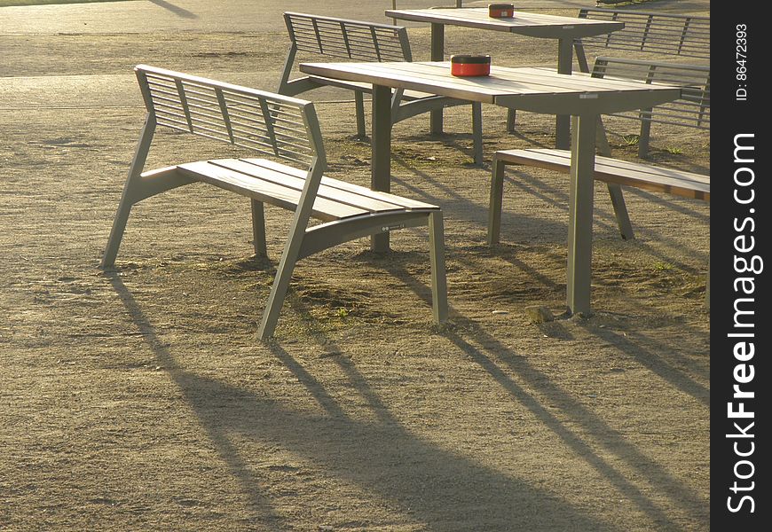 Ashtrays on empty tables and chairs on grassy lawn in sunshine. Ashtrays on empty tables and chairs on grassy lawn in sunshine.