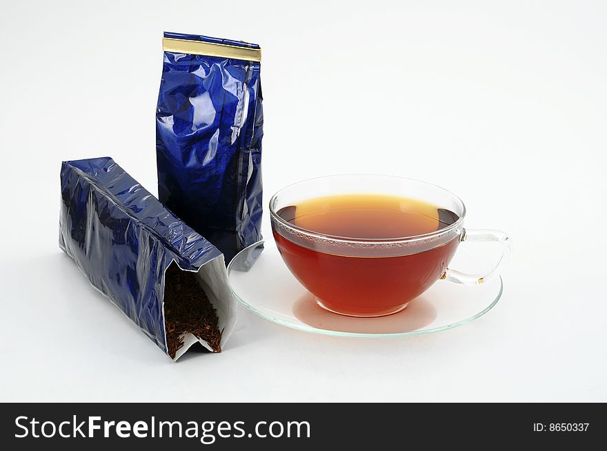One tea cup and two blue shiny tea bags on white background