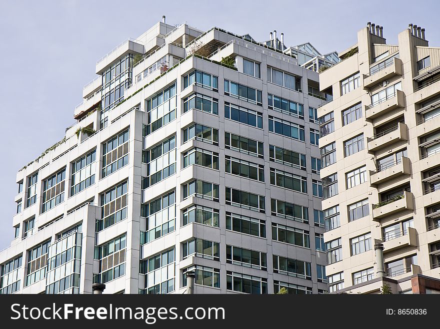 A large terraced condominium tower with many windows. A large terraced condominium tower with many windows