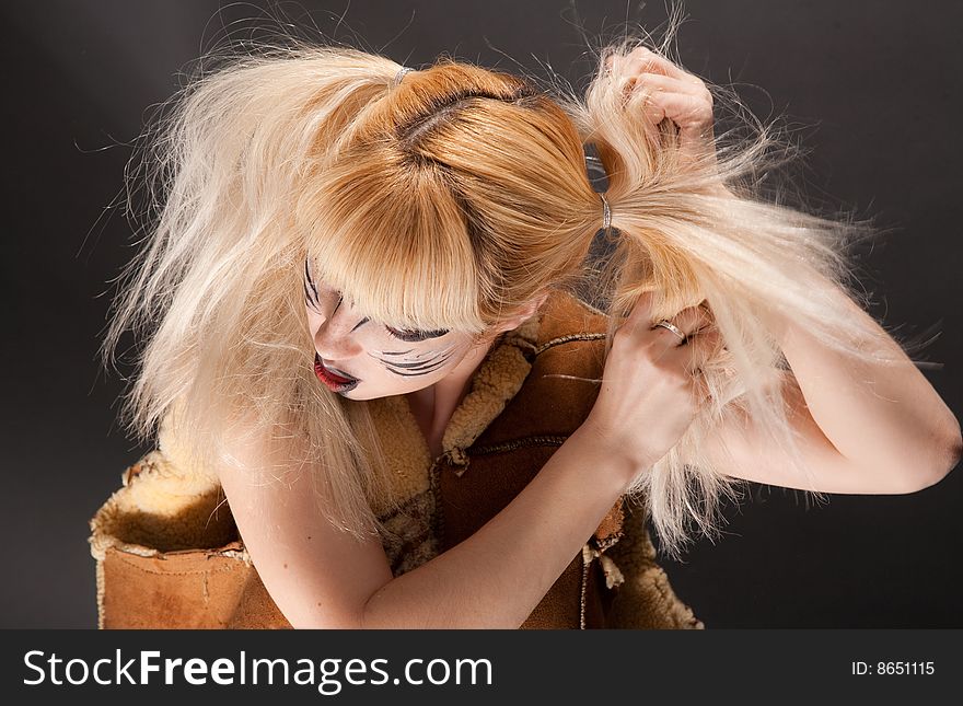 Beatiful young girl with make-up in cat style is brushing her hair. Beatiful young girl with make-up in cat style is brushing her hair.