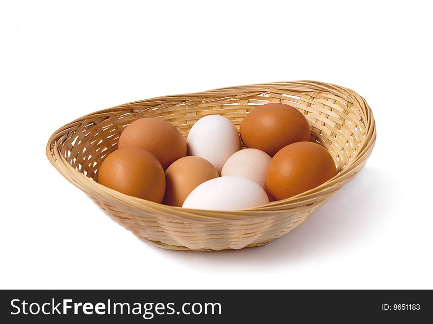 A few chicken eggs, lyings in a braiding small basket. A few chicken eggs, lyings in a braiding small basket