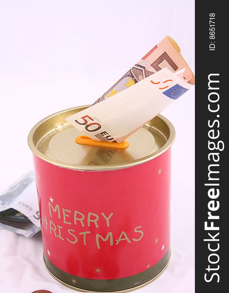 Christmas savings, euro bills and coins with velvet decorations