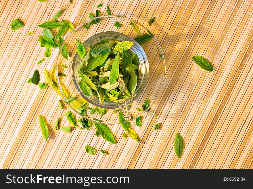 Cup full of leaves - green tea freshness.