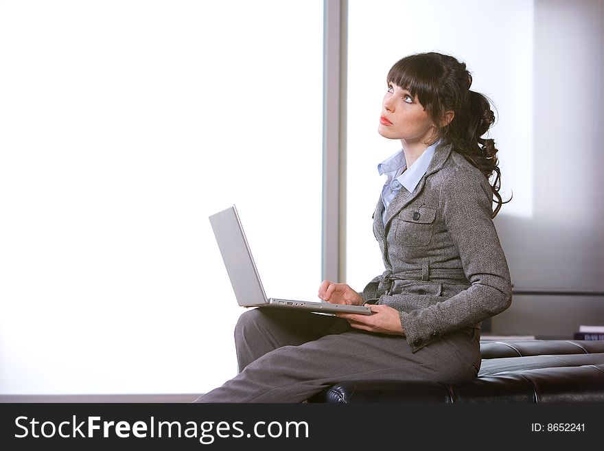 Business woman thinking in modern office with laptop. Business woman thinking in modern office with laptop