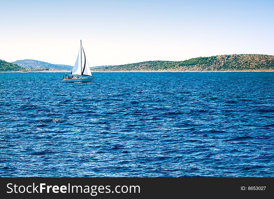 A Sailboat And Deep Blue Sea