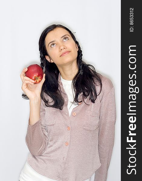 Portrait of smiling young woman holding apple, isolated on white background