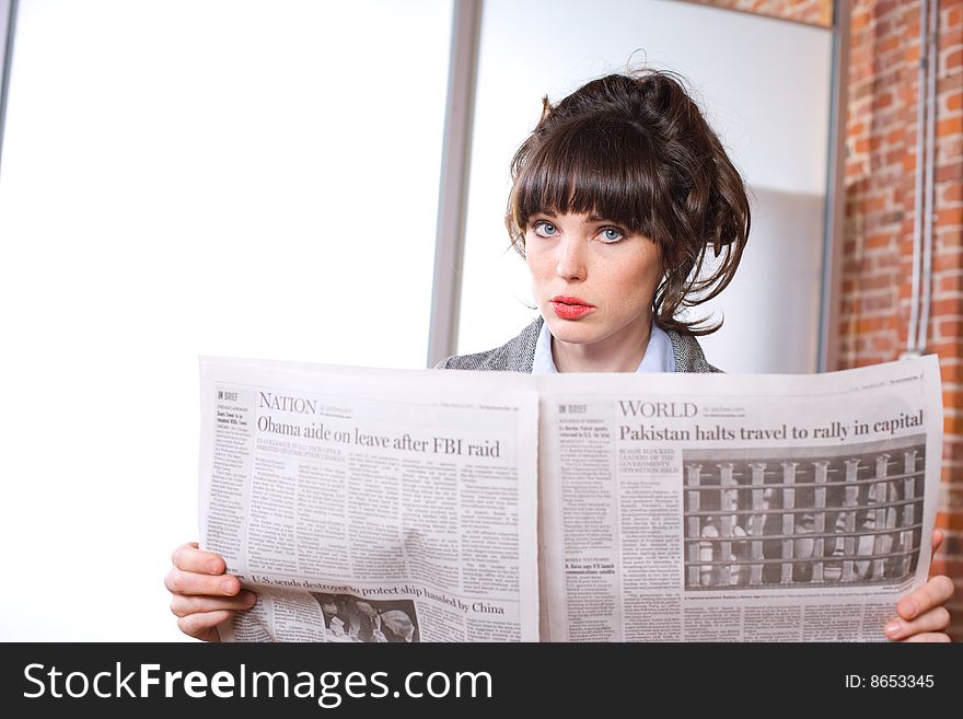Business woman reading the news paper in modern office. Business woman reading the news paper in modern office