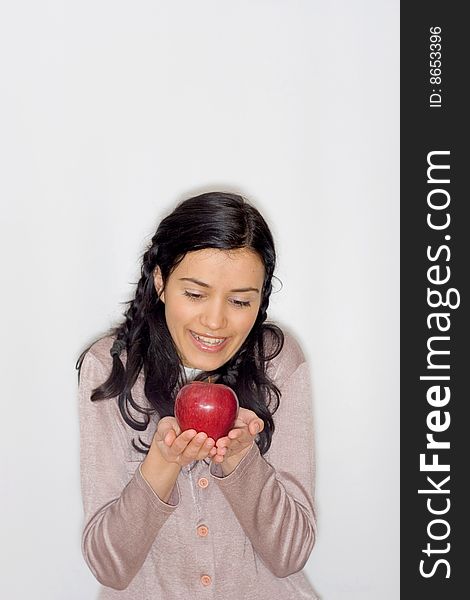 Portrait of smiling young woman holding apple, isolated on white background