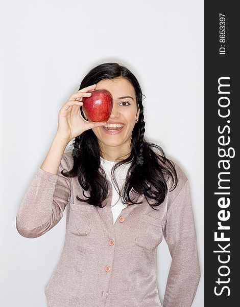 Portrait of smiling young woman holding apple, isolated on white background