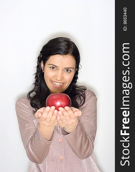 Portrait of smiling young woman holding apple, isolated on white background