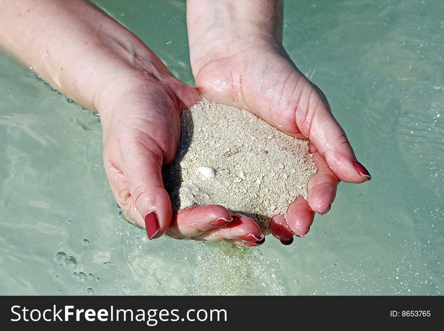 Woman's hands with sand at the beach. Woman's hands with sand at the beach.