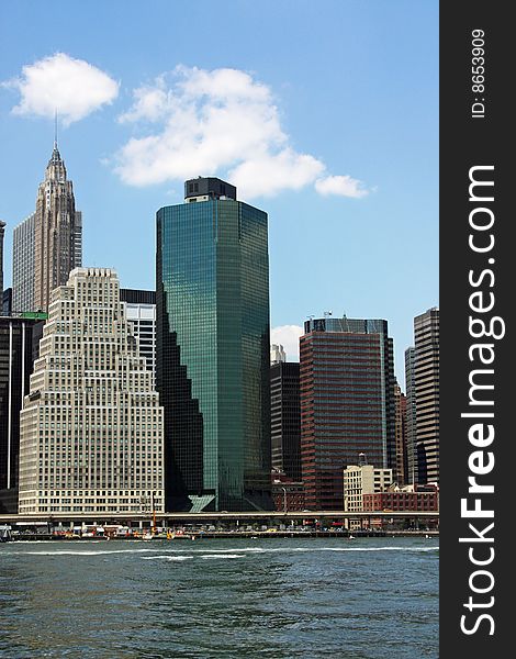 Tall modern buildings in Lower Manhattan, New York as seen from the East river. Tall modern buildings in Lower Manhattan, New York as seen from the East river.