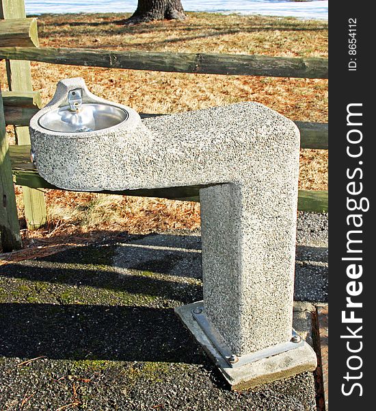 Classic water fountain in angled concrete base.