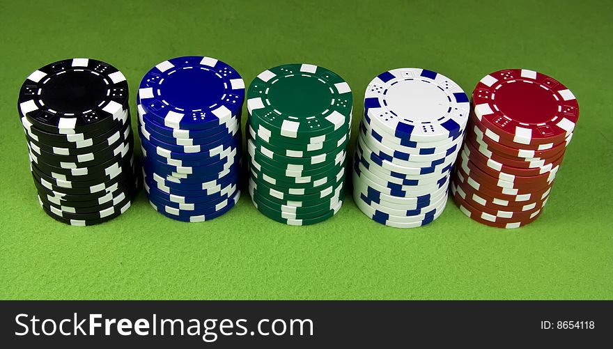 Five color poker casino stacks over green table