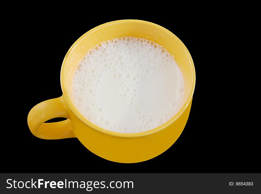 Fresh milk in big yellow cup on black background. Clipping path is included.