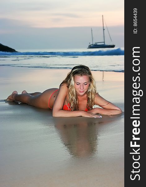 Blonde girl lying on the sand beach. Blonde girl lying on the sand beach