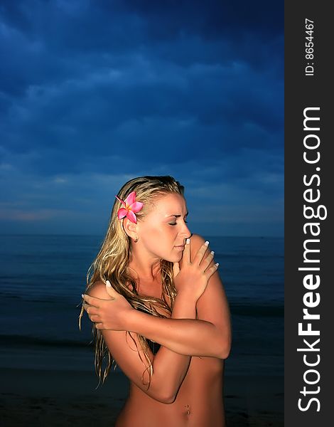 Young lady standing on the beach at night. Young lady standing on the beach at night