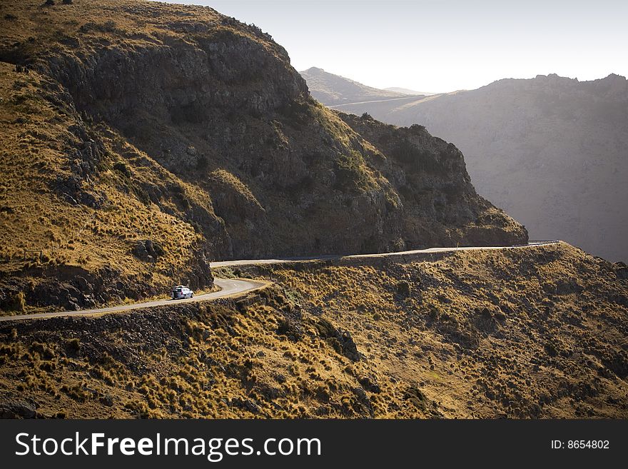 A car travels along on a twisty mountain road. A car travels along on a twisty mountain road