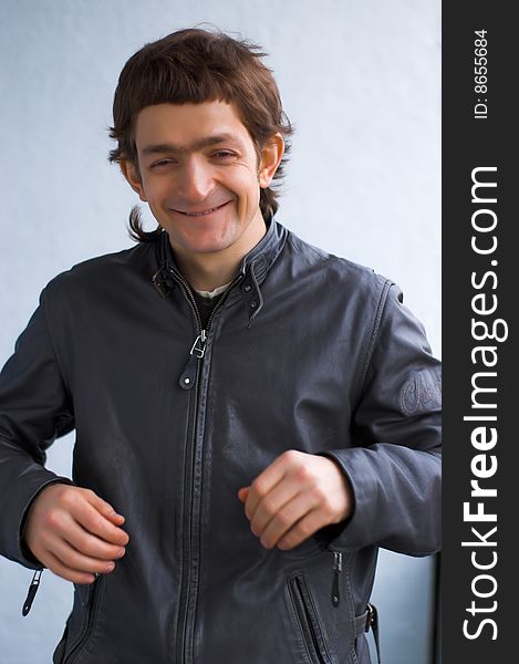 The young laughing person in a black leather jacket. The young laughing person in a black leather jacket.