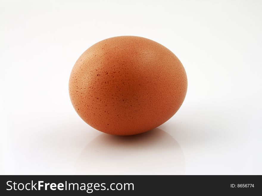 A closeup of an uncracked egg on a white background