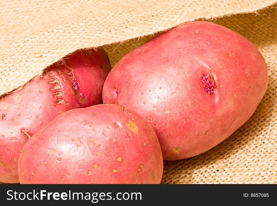 Burlap bag of potatoes spilling out of the bag