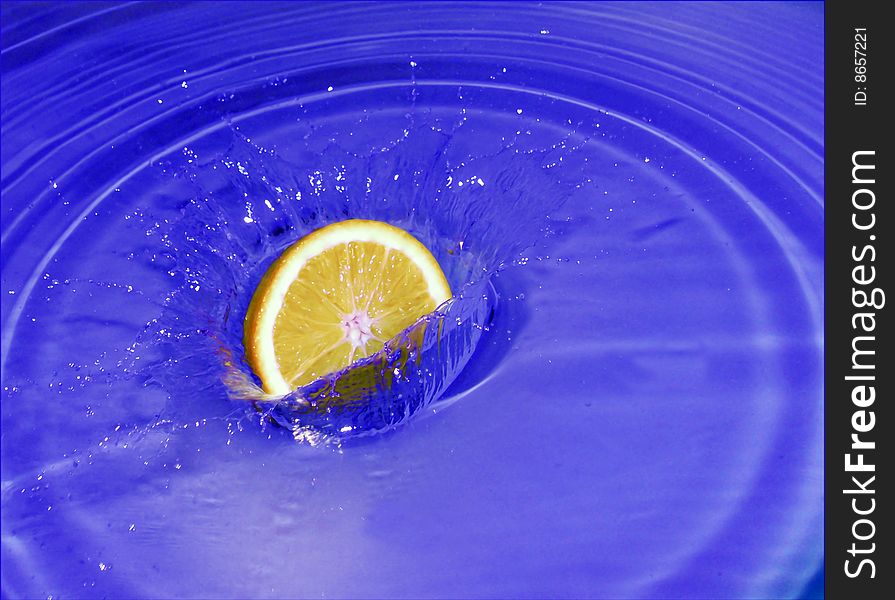 A fresh citrus falls in water. A fresh citrus falls in water