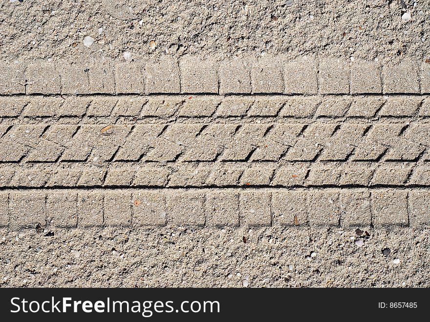 Sand with tyre tread for use as background.