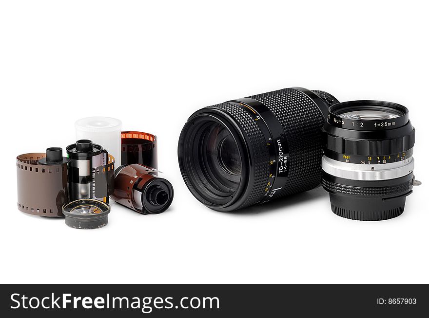 Two camera lenses and film rolls on white background