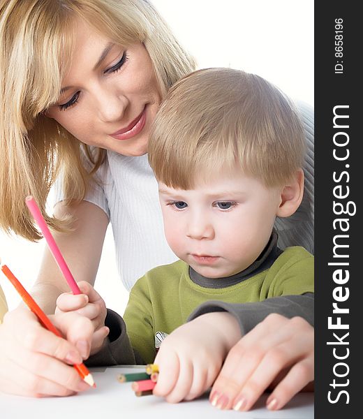 The little boy draws pencils with mum. The little boy draws pencils with mum