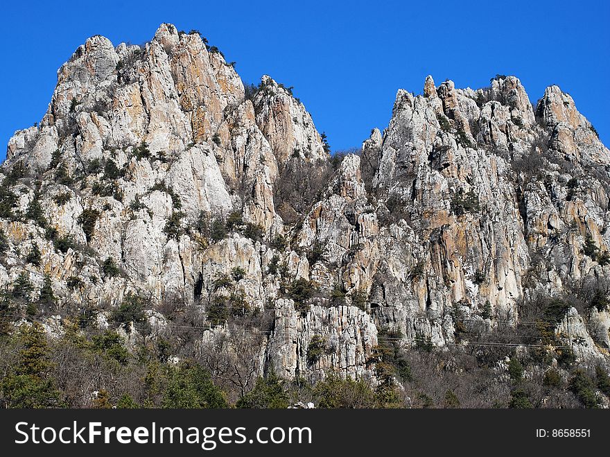 Beautiful high mountain rocks against blue sky background