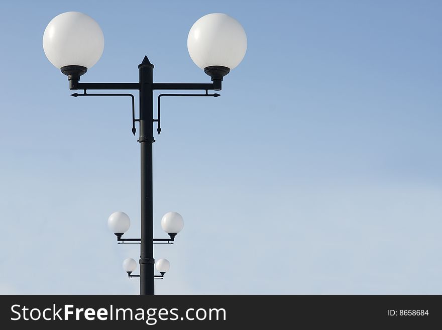 Lampposts standing in a row against the blue sky