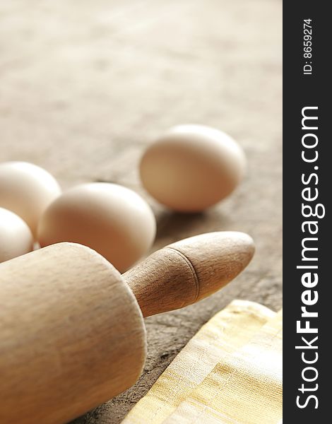 Eggs and rolling-pin on old wooden table