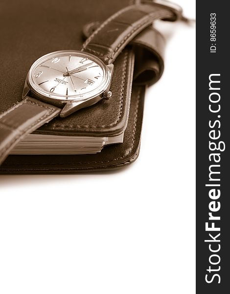 Leather organizer and watch isolated (shallow focus)